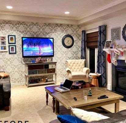 Before: a busy living room with damask wallpaper, a dark leather sofa, a low wooden coffee table and a wall of small frames.
