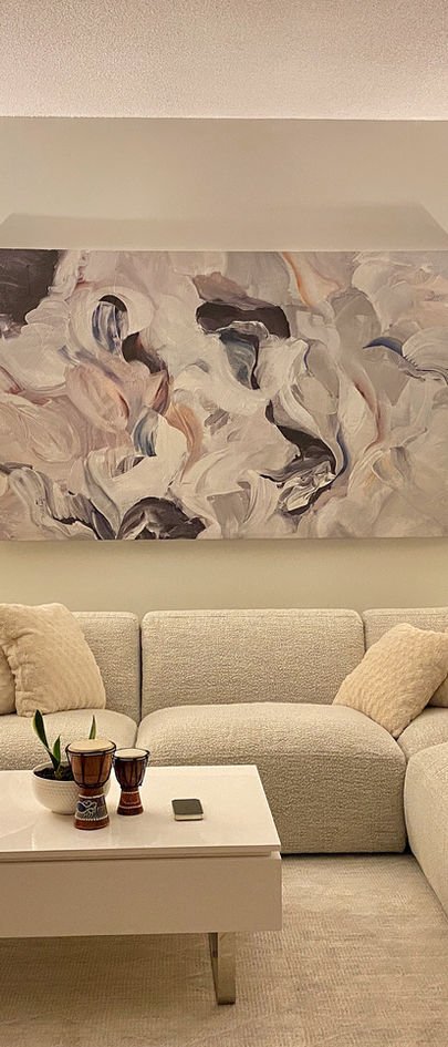 A soft abstract canvas above a cream boucle sofa, with a white coffee table.
